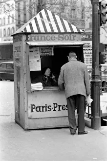 A Morning newspaper reader picks up his paper from a kiosk in the 15th district of Paris A Morning newspaper reader picks up his paper from a kiosk in the 15th district of Paris