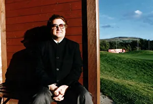 Music - Singer and songwriter Gerry Rafferty entertainer sitting brown fence green field Music - Singer and songwriter Gerry Rafferty entertainer sitting brown fence green field