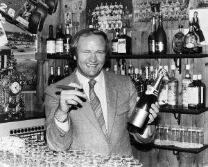 New Manchester United football manager Ron Atkinson holds up a bottle of champagne in one New Manchester United football manager Ron Atkinson holds up a bottle of champagne in one