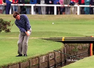 Nick Faldo plays over the Swilken burn at the 1st after putting his ball in the water in Nick Faldo plays over the Swilken burn at the 1st after putting his ball in the water in
