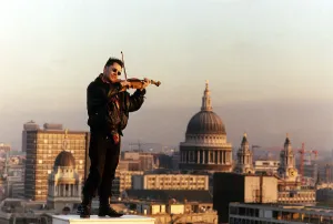 Nigel Kennedy the violinist playing his violin overlooking London Nigel Kennedy the violinist playing his violin overlooking London