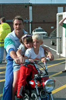 NIGEL MANSELL AND CHILDREN CHLOE MANSELL AND GREG MANSELL ON A BIKE AT THE FORMULA 1 NIGEL MANSELL AND CHILDREN CHLOE MANSELL AND GREG MANSELL ON A BIKE AT THE FORMULA 1