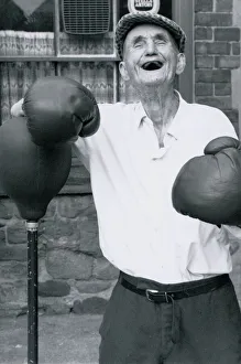 Old age pensioner Jackie McGuire aged 92 Standing beside punch ball wearing boxing Old age pensioner Jackie McGuire aged 92 Standing beside punch ball wearing boxing