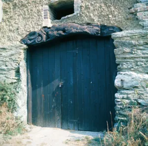 The old figurehead from a ship used as a lintel over a barn door in Crantock, Cornwall The old figurehead from a ship used as a lintel over a barn door in Crantock, Cornwall