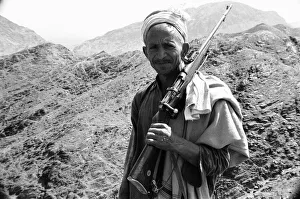Old Pathan tribesman carries a old bolt action rifle at the Khyber Pass on the border Old Pathan tribesman carries a old bolt action rifle at the Khyber Pass on the border