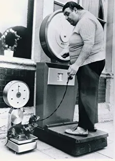 An overweight owner weighs himself on a set of Avery scales An overweight owner weighs himself on a set of Avery scales