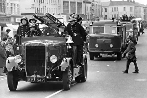 A parade of fire engines past and present - one man appears unimpressed as he tries to A parade of fire engines past and present - one man appears unimpressed as he tries to