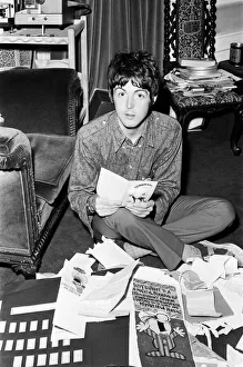 Paul McCartney of The Beatles sitting on the floor cross legged as he opens up birthday Paul McCartney of The Beatles sitting on the floor cross legged as he opens up birthday