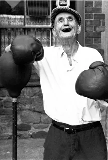 People - Old Man, Jackie McGuire, without any teeth wearing boxing gloves standing by a People - Old Man, Jackie McGuire, without any teeth wearing boxing gloves standing by a