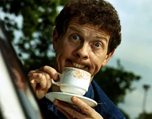 Phil Cool Comic pulling funny face holding cup and saucer Dbase Phil Cool Comic pulling funny face holding cup and saucer Dbase