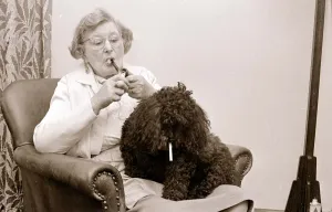 The Poodle who eats cigarettes An old lady smoking a pipe with her pet poodle who The Poodle who eats cigarettes An old lady smoking a pipe with her pet poodle who