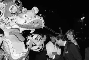 Prince Charles and Princess Diana observing a Chinese dragon as they attend the premier Prince Charles and Princess Diana observing a Chinese dragon as they attend the premier