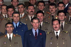 Prince Charles wearing a blue suit with poppy stands among officers Prince Charles wearing a blue suit with poppy stands among officers