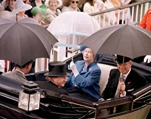 Queen protects herself from the rain as she arrives in a horse-drawn carriage at Queen protects herself from the rain as she arrives in a horse-drawn carriage at