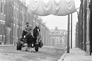 A rag and bone man at the reins of his horse and cart seen here travelling the streets of A rag and bone man at the reins of his horse and cart seen here travelling the streets of
