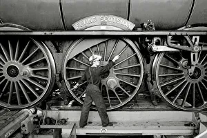 Railway worker shows the scale of the wheels on the Flying Scotsman steam train Railway worker shows the scale of the wheels on the Flying Scotsman steam train