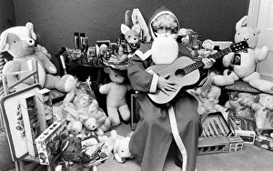 Rod Johnson, a guitar playing Father Christmas, surrounded by toys Rod Johnson, a guitar playing Father Christmas, surrounded by toys