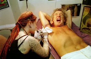 Rod Stewart grimaces in pain 21st June 1999 as tattoo artsit Ronda Hoelzer Rod Stewart grimaces in pain 21st June 1999 as tattoo artsit Ronda Hoelzer