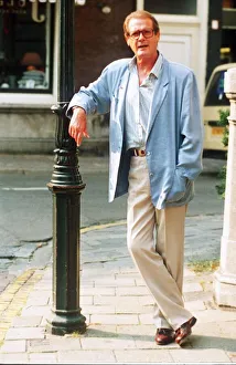 Roger Moore actor leaning against lamp post Roger Moore actor leaning against lamp post
