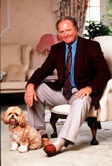 Ron Atkinson Football manager sitting on chair at home with his pet dog . January 1991 Ron Atkinson Football manager sitting on chair at home with his pet dog . January 1991