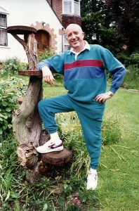 Roy Castle TV Presenter in garden with foot on tree Roy Castle TV Presenter in garden with foot on tree