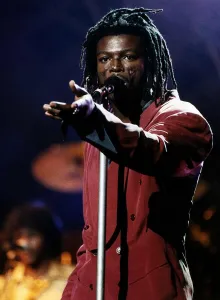 Seal singer on stage sings into microphone with dreadlocks Seal singer on stage sings into microphone with dreadlocks