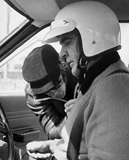 Sean Connery being strapped into motor car for lesson in grand prix driving at Sean Connery being strapped into motor car for lesson in grand prix driving at