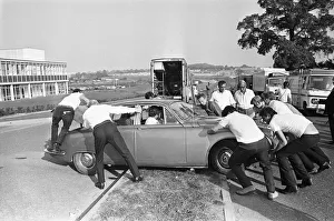 Set dressers move a Jaguar Mark II car for the next shot during location filming of Set dressers move a Jaguar Mark II car for the next shot during location filming of