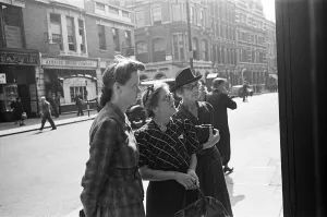 Shoppers looking for a bargain read the small ads outside a Earls Court News Agents Shoppers looking for a bargain read the small ads outside a Earls Court News Agents