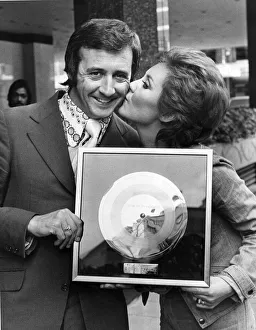 Singer Tony Christie receives a kiss from Lulu who presented him with his gold disc in Singer Tony Christie receives a kiss from Lulu who presented him with his gold disc in