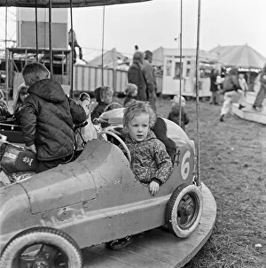 A small child enjoying the thrill of the merry-go-round at Silcocks Fair at Skelmersdale A small child enjoying the thrill of the merry-go-round at Silcocks Fair at Skelmersdale