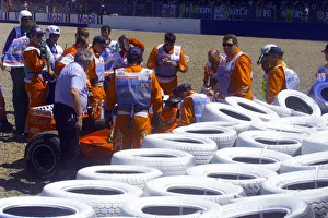 Stewards try to help Michael Schumacher out of his Ferrari after crashing into the wall Stewards try to help Michael Schumacher out of his Ferrari after crashing into the wall