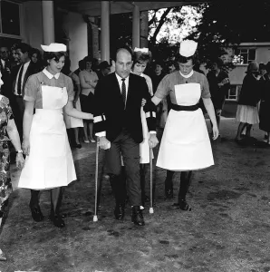 Stirling Moss motor racing driver leaving hospital 1962 on crutches with help of Stirling Moss motor racing driver leaving hospital 1962 on crutches with help of