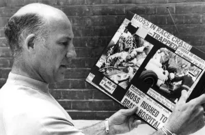 Stirling Moss reading clippings of his crash during race - August 1982 Stirling Moss reading clippings of his crash during race - August 1982