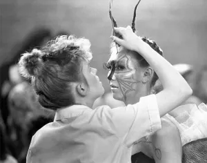 A student puts the final touches to The Insect hair style in a hair A student puts the final touches to The Insect hair style in a hair