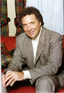 Tom Jones British singer Sitting on a red couch Tom Jones British singer Sitting on a red couch