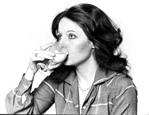 Woman drinking a cocktail from a wine glass September 1977 Woman drinking a cocktail from a wine glass September 1977