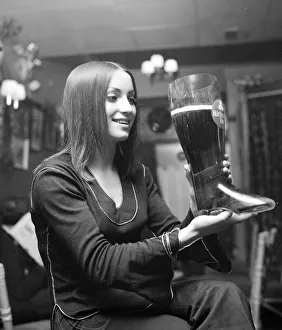 Woman drinking lager from a glass boot holding nearly 5 pints Woman drinking lager from a glass boot holding nearly 5 pints