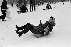 A woman sledging on a washing up bowl in Greenwich Park, London, 27th December 1970 A woman sledging on a washing up bowl in Greenwich Park, London, 27th December 1970