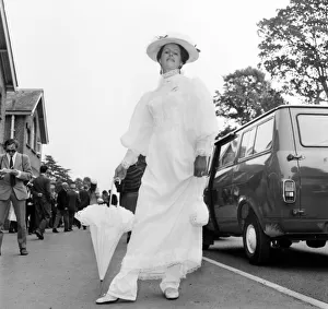 Woman wearing long white dress with matching hat and umbrella on the first day of Royal Woman wearing long white dress with matching hat and umbrella on the first day of Royal