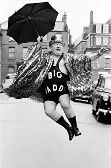 Wrestler Shirley Crabtree alias Big Daddy jumps in the air with an umbrella Wrestler Shirley Crabtree alias Big Daddy jumps in the air with an umbrella