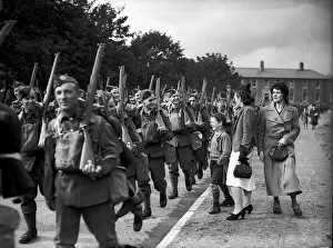 WW2 British Soldiers in England march along the road past family WW2 British Soldiers in England march along the road past family