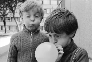 Eight year old Joseph Clifford of Hackney blows up his balloon as his younger brother Eight year old Joseph Clifford of Hackney blows up his balloon as his younger brother