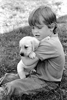 A young boy with a labrador puppy at the Frant Kennels in Hildenborough near Tonbridge A young boy with a labrador puppy at the Frant Kennels in Hildenborough near Tonbridge