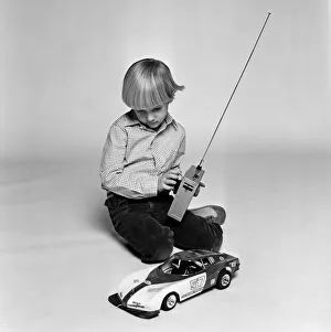 A young boy playing with a remote control car. December 1980 A young boy playing with a remote control car. December 1980