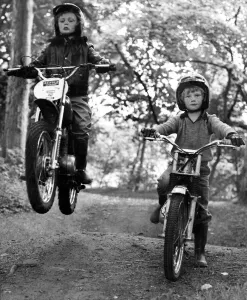 Two young boys Paul and Jason Wilson ride on their motorbikes on a woodland track Two young boys Paul and Jason Wilson ride on their motorbikes on a woodland track