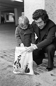 A Young Christmas shopper with his dad in Birmingham. 20th December 1975 A Young Christmas shopper with his dad in Birmingham. 20th December 1975