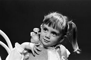 Images Dated 5th December 1982: A young girl holding an E. T. from the film E. T. the Extra-Terrestrial. 5th December 1982