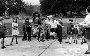 Young girl jumping over a skipping rope in the playground of the National School at Young girl jumping over a skipping rope in the playground of the National School at
