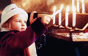 A young girl Katie Hughes Boyton lights a candle for peace at Westminster Cathedral at A young girl Katie Hughes Boyton lights a candle for peace at Westminster Cathedral at